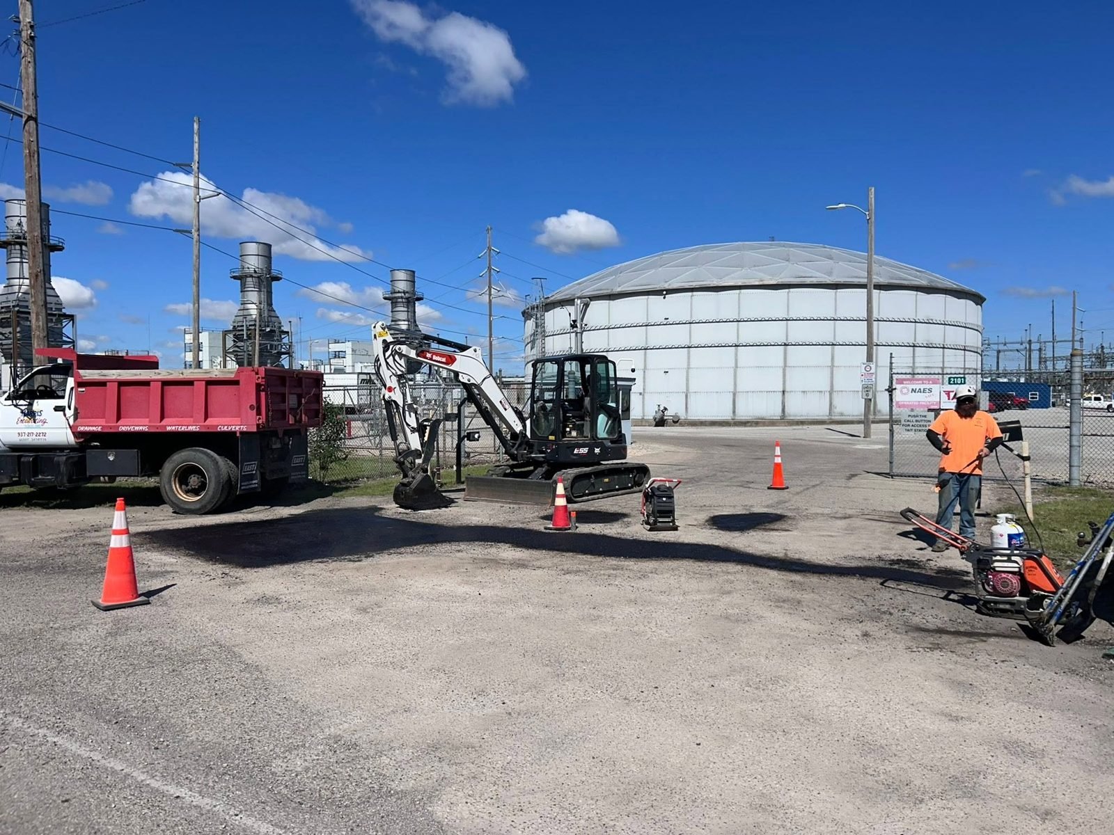 Harris Excavating dump truck, Bobcat E55 and crew patching pavement inside a power generating station